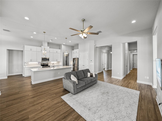 living area with visible vents, a ceiling fan, recessed lighting, baseboards, and dark wood-style flooring