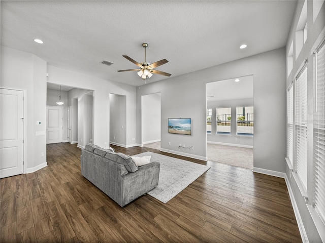 living area with a ceiling fan, visible vents, baseboards, recessed lighting, and dark wood-type flooring