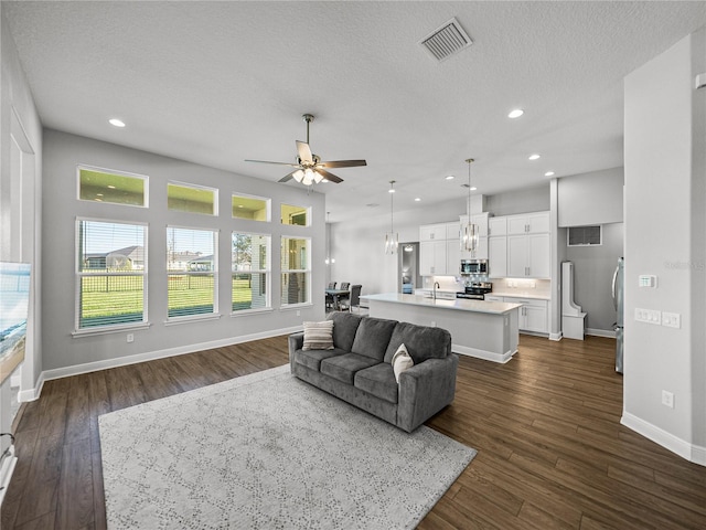 living area with baseboards, visible vents, recessed lighting, ceiling fan, and dark wood-type flooring