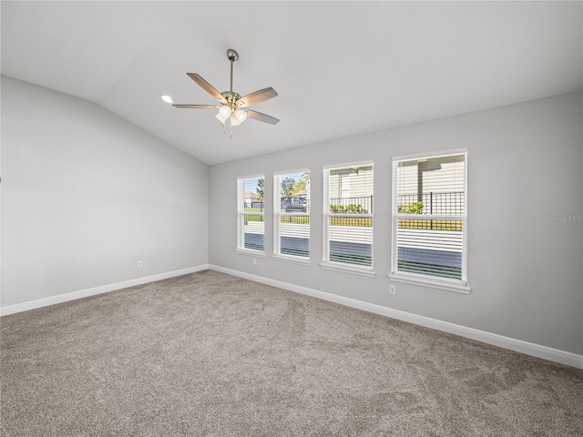 spare room featuring carpet floors, baseboards, ceiling fan, and vaulted ceiling