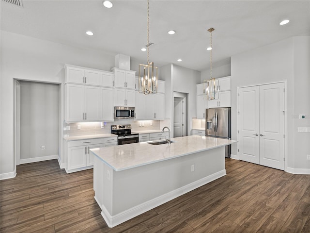 kitchen featuring dark wood-style flooring, a sink, appliances with stainless steel finishes, backsplash, and a chandelier