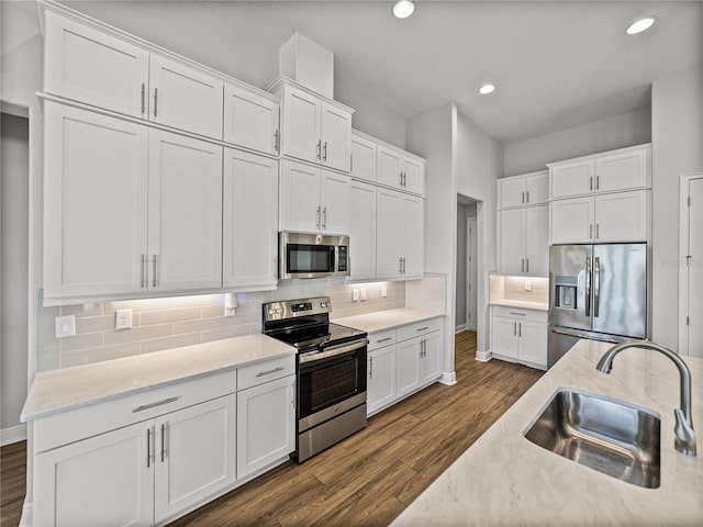 kitchen with a sink, dark wood finished floors, tasteful backsplash, and stainless steel appliances