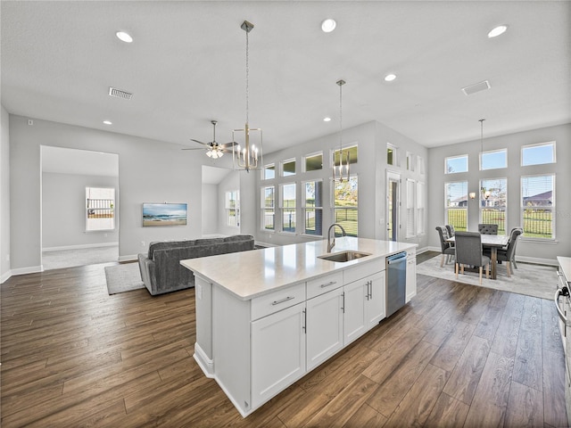 kitchen with dishwasher, light countertops, dark wood-style floors, white cabinets, and a sink