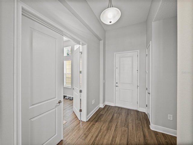 corridor with dark wood-type flooring and baseboards