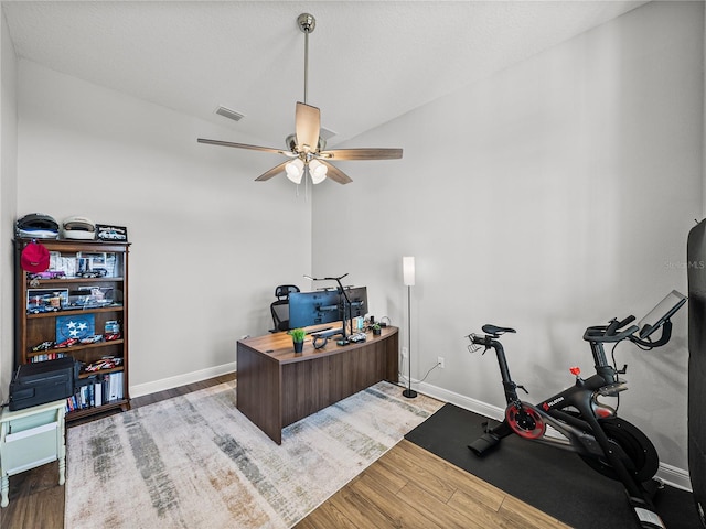 office space with baseboards, wood finished floors, visible vents, and ceiling fan