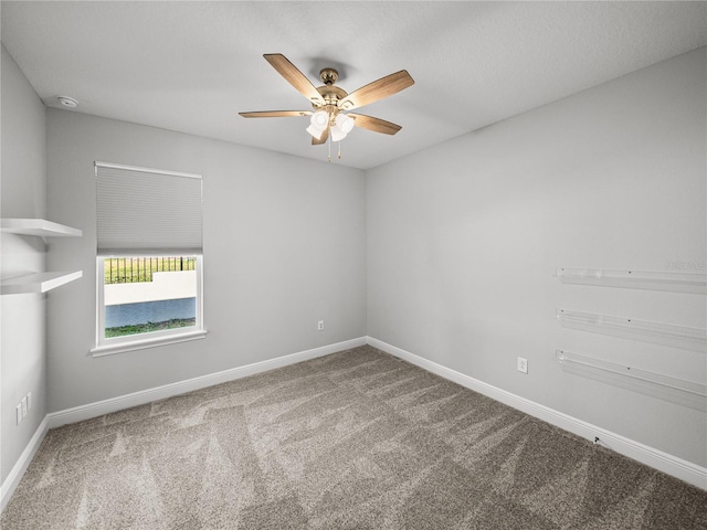 carpeted empty room featuring baseboards and ceiling fan