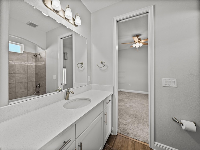 bathroom with visible vents, a ceiling fan, shower / washtub combination, wood finished floors, and vanity