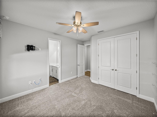 unfurnished bedroom with visible vents, connected bathroom, baseboards, carpet floors, and a closet