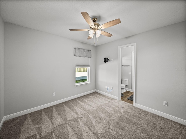 unfurnished bedroom with connected bathroom, baseboards, ceiling fan, and carpet flooring