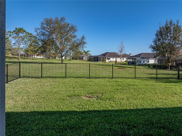 view of yard featuring fence and a residential view