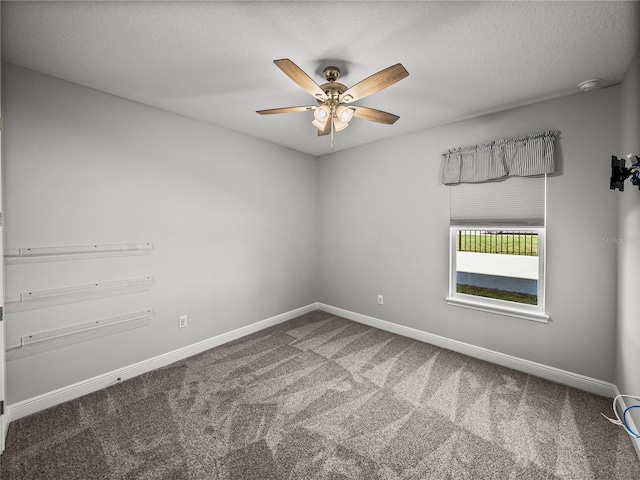 spare room featuring carpet flooring, a textured ceiling, baseboards, and ceiling fan