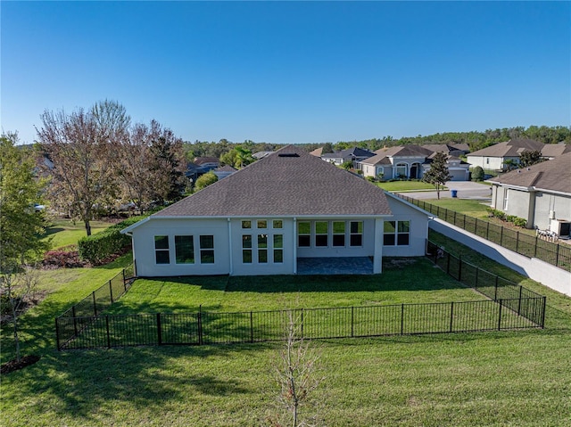 rear view of house with a yard, fence, a residential view, and stucco siding