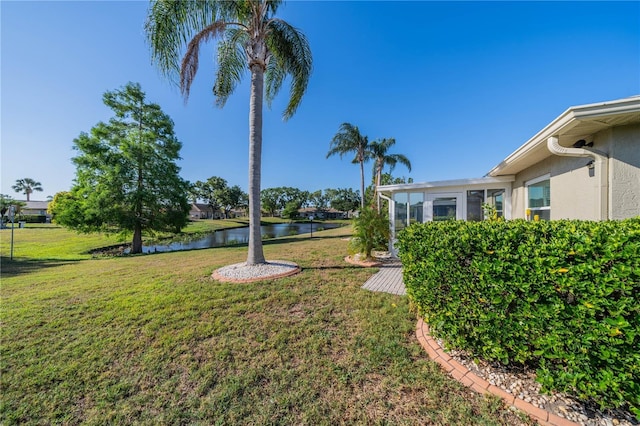 view of yard with a water view and a sunroom