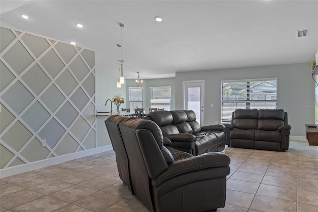 living room with light tile patterned flooring, visible vents, and a healthy amount of sunlight