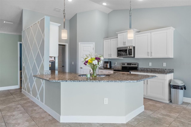 kitchen with dark stone countertops, white cabinets, appliances with stainless steel finishes, and high vaulted ceiling