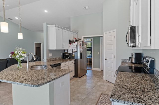 kitchen featuring a sink, appliances with stainless steel finishes, a peninsula, white cabinets, and light stone countertops