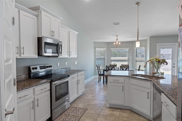 kitchen featuring visible vents, light tile patterned floors, white cabinets, stainless steel appliances, and a sink