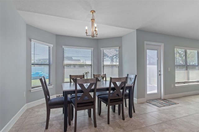 dining area featuring light tile patterned flooring, a chandelier, and a healthy amount of sunlight