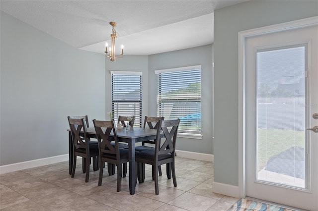 dining space with baseboards, a notable chandelier, light tile patterned flooring, and a textured ceiling