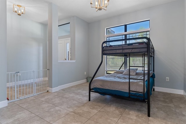 bedroom with multiple windows, baseboards, an inviting chandelier, and a towering ceiling