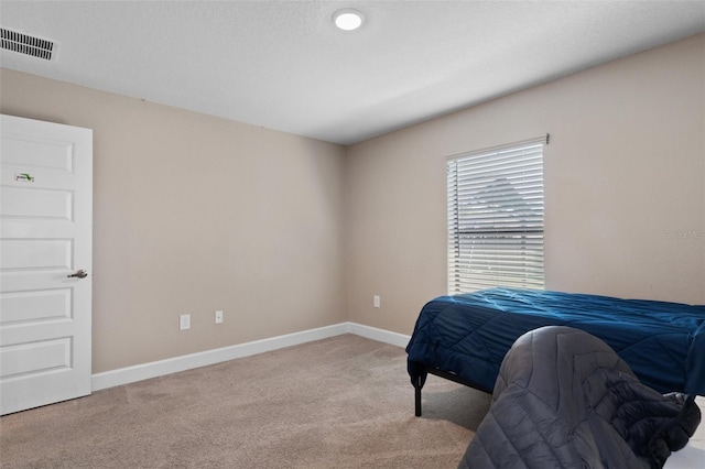 carpeted bedroom featuring baseboards and visible vents