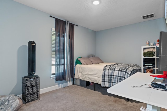 carpeted bedroom featuring visible vents, a textured ceiling, and baseboards