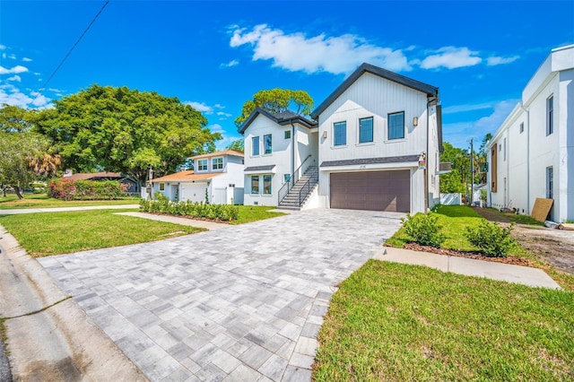 view of front of property with an attached garage, decorative driveway, and a front yard