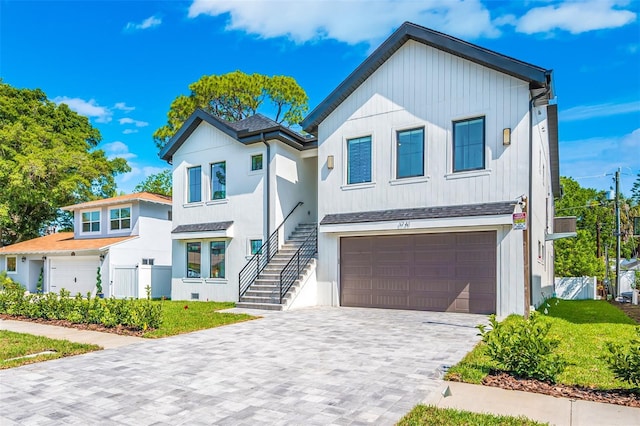 modern farmhouse style home with a shingled roof, fence, stairs, decorative driveway, and a garage