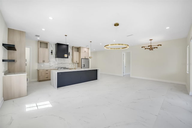 kitchen with a center island with sink, recessed lighting, stainless steel fridge, marble finish floor, and open floor plan