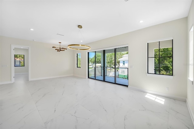 unfurnished room featuring baseboards, a notable chandelier, and marble finish floor