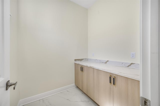 bathroom featuring marble finish floor and baseboards