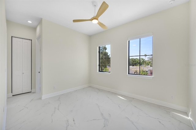 spare room featuring a ceiling fan, recessed lighting, baseboards, and marble finish floor