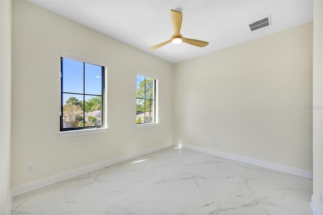 unfurnished room featuring visible vents, marble finish floor, baseboards, and ceiling fan