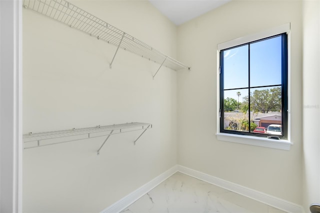 spacious closet featuring marble finish floor