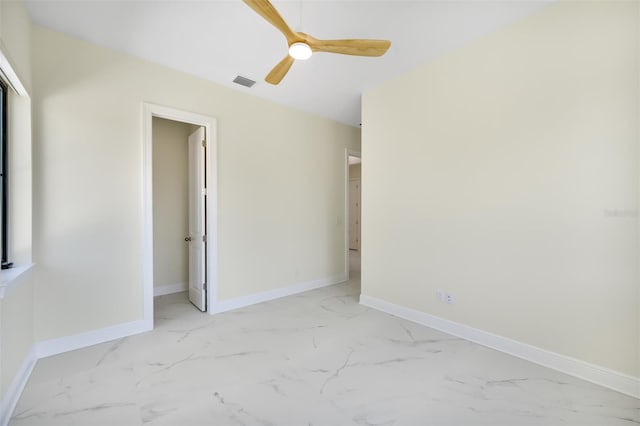 unfurnished room with visible vents, marble finish floor, a ceiling fan, and baseboards