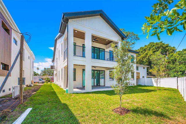 rear view of house featuring ceiling fan, a fenced backyard, a balcony, a patio area, and a yard