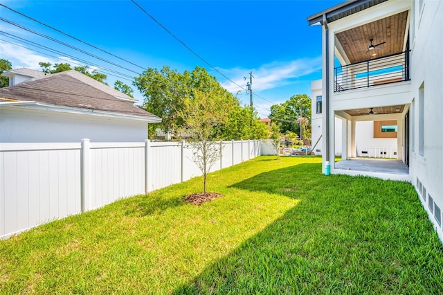 view of yard with a fenced backyard, a balcony, ceiling fan, and a patio area