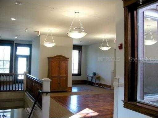 interior space with wood finished floors, baseboards, and pendant lighting