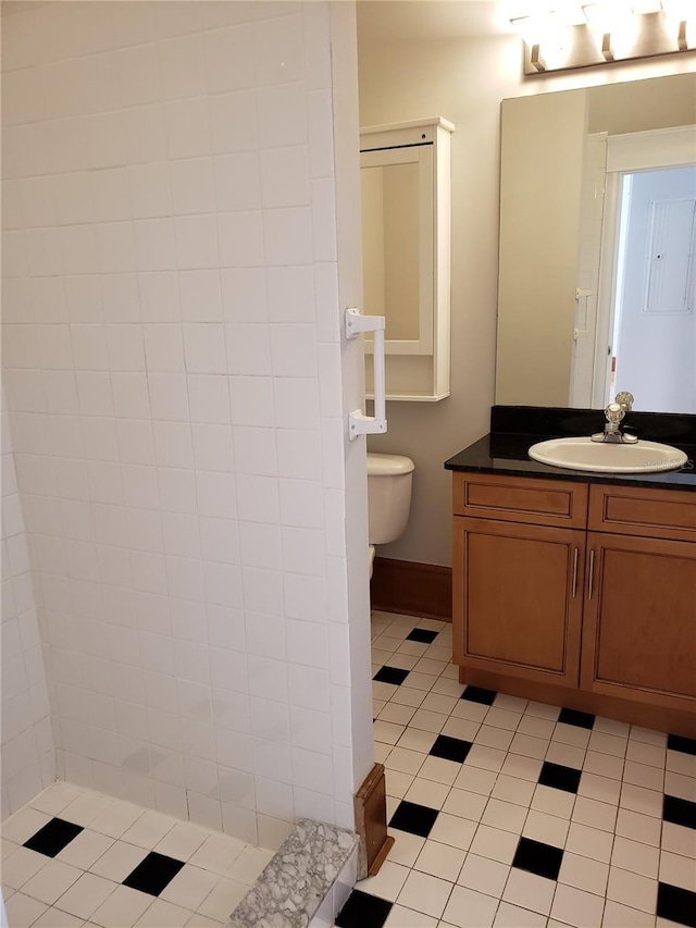 bathroom featuring tile patterned flooring, toilet, vanity, and baseboards