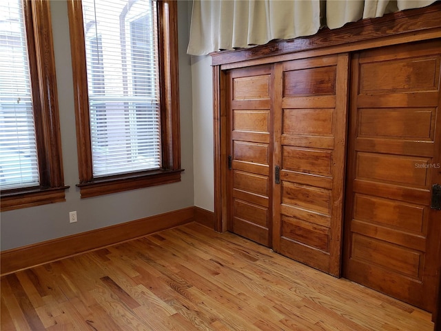 unfurnished bedroom featuring baseboards and light wood finished floors