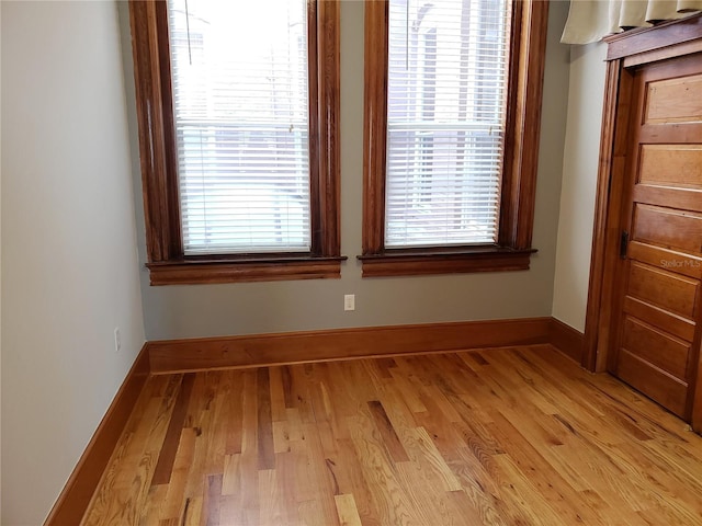 unfurnished dining area featuring baseboards and light wood finished floors