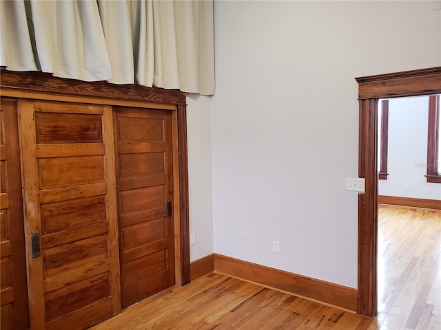 unfurnished bedroom with light wood finished floors and baseboards