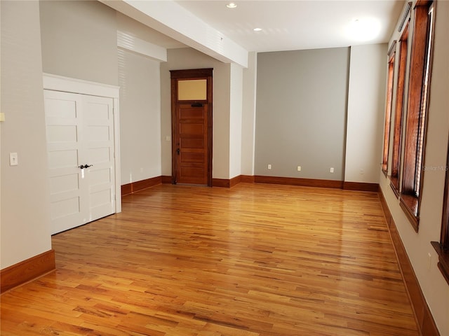 unfurnished room featuring recessed lighting, light wood-type flooring, and baseboards