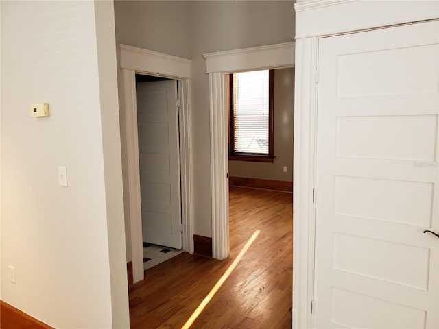 hallway with baseboards and wood finished floors