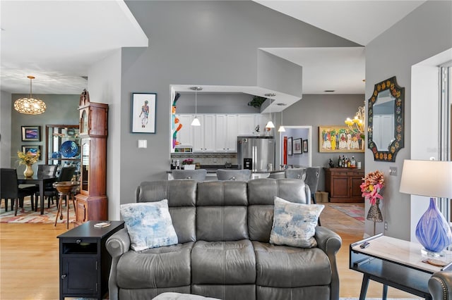 living room with an inviting chandelier and light wood-style flooring