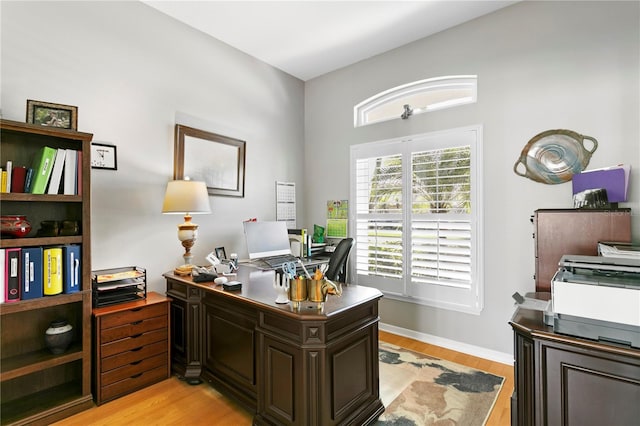 home office featuring baseboards and light wood finished floors