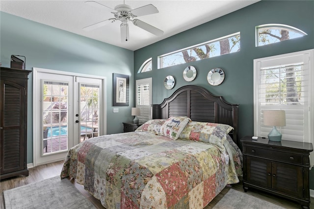 bedroom with multiple windows, french doors, wood finished floors, and access to outside