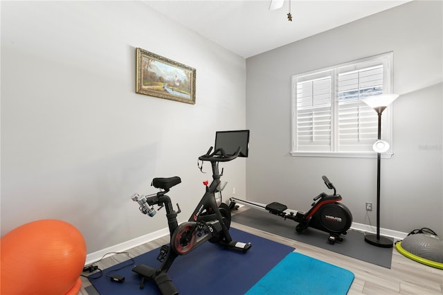 exercise area featuring baseboards and wood finished floors