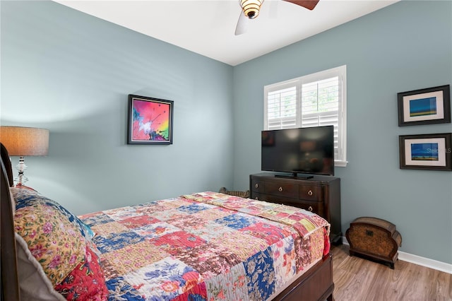 bedroom with a ceiling fan, wood finished floors, and baseboards