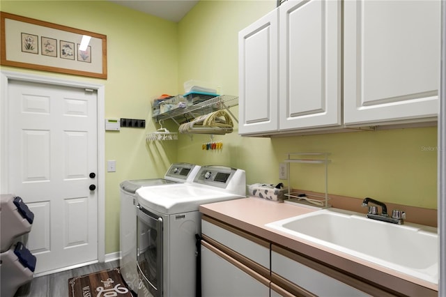 washroom with dark wood finished floors, cabinet space, independent washer and dryer, and a sink